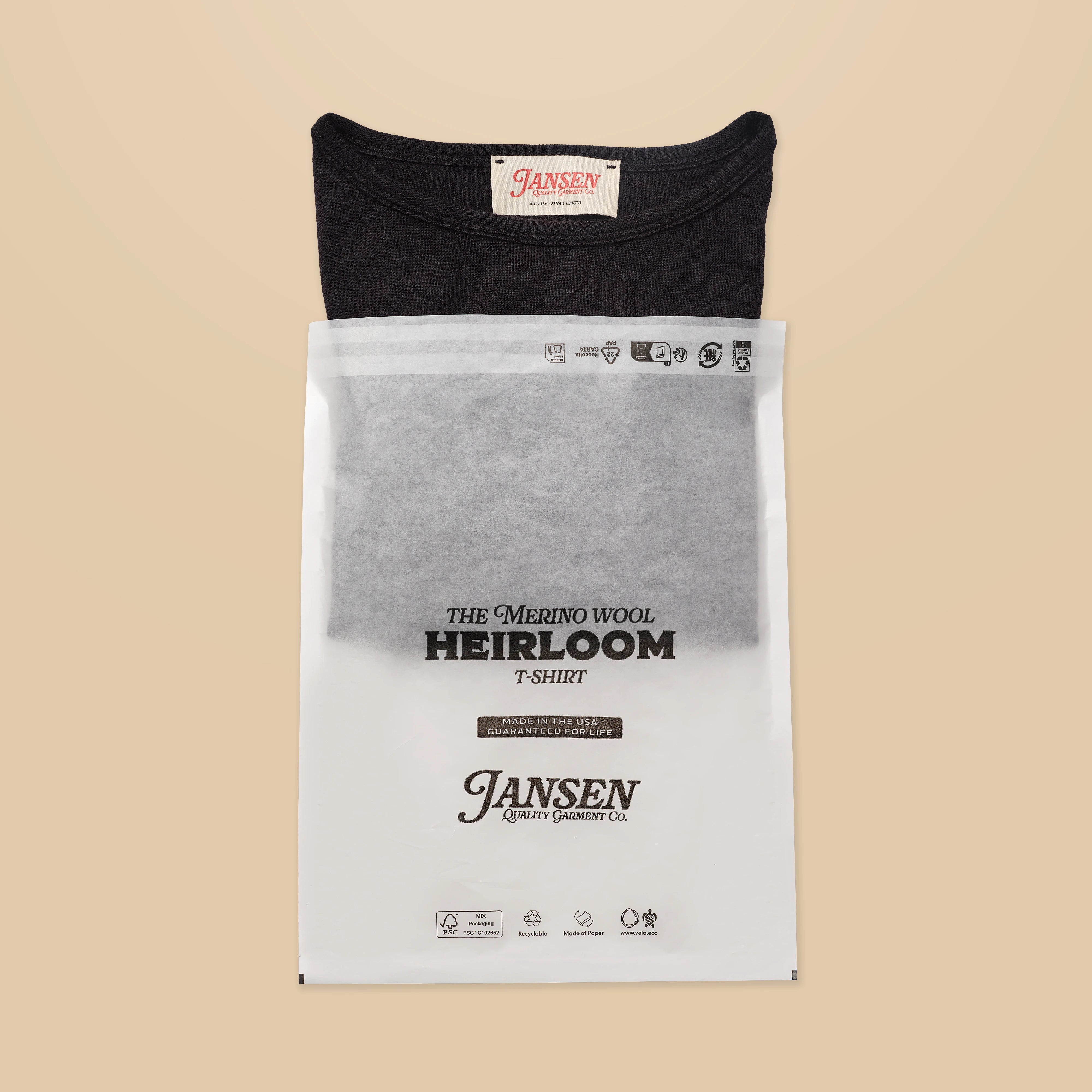 Black packaged tee shirt with 'Jansen' label on a beige background