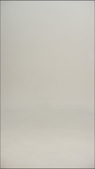 Video of a man wearing a white/cream wool tee shirt and blue jeans walking into frame, turning to show the tee, then walking out of frame.