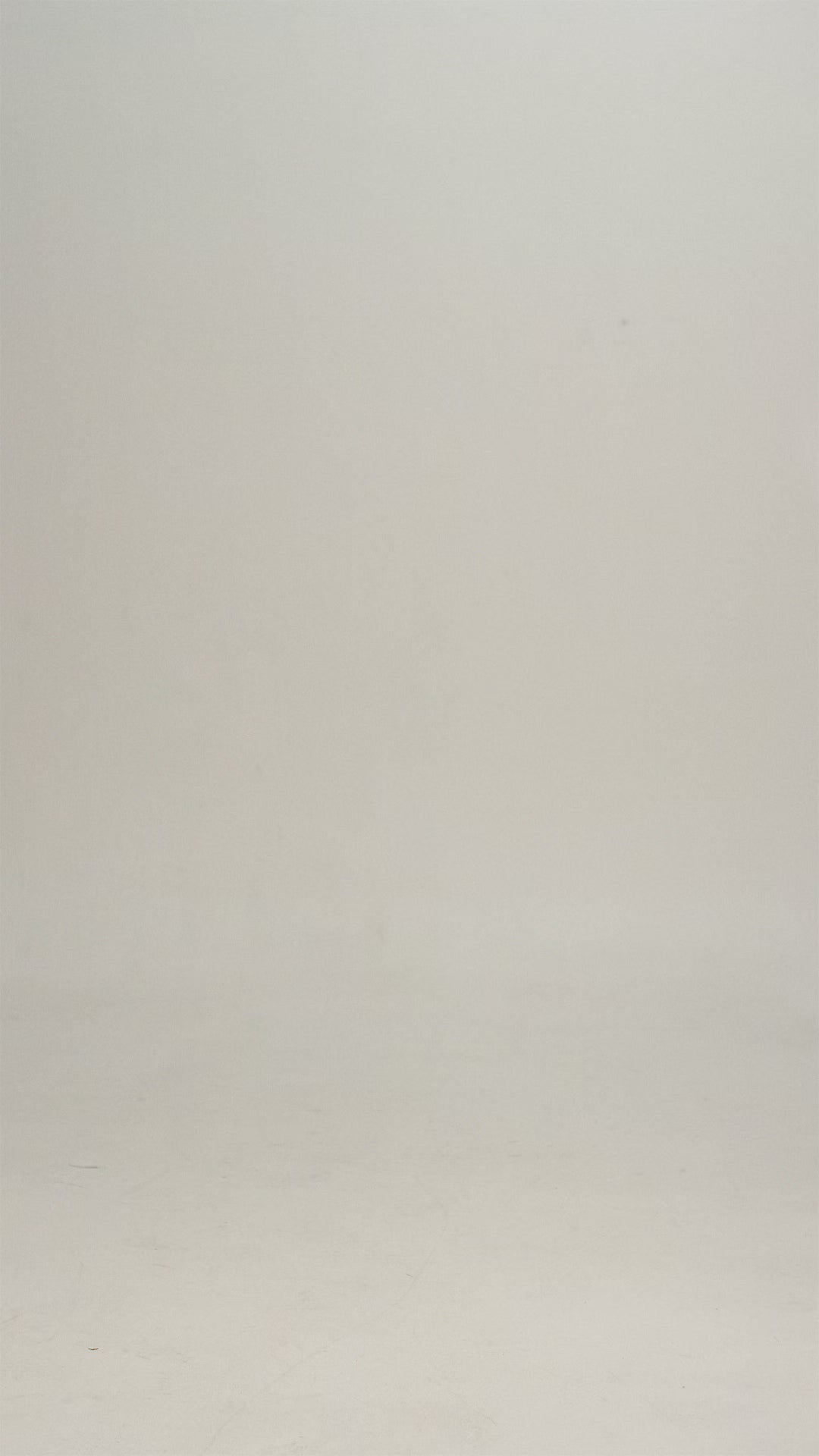Woman wearing a white/natural colored tee shirt and blue jeans walking into frame, turning to show the shirt, then walking out of frame.