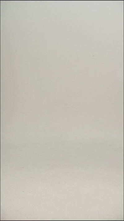 Video of a woman wearing a black wool tee shirt and blue jeans walking into frame, turning to show the tee, then walking out of frame.